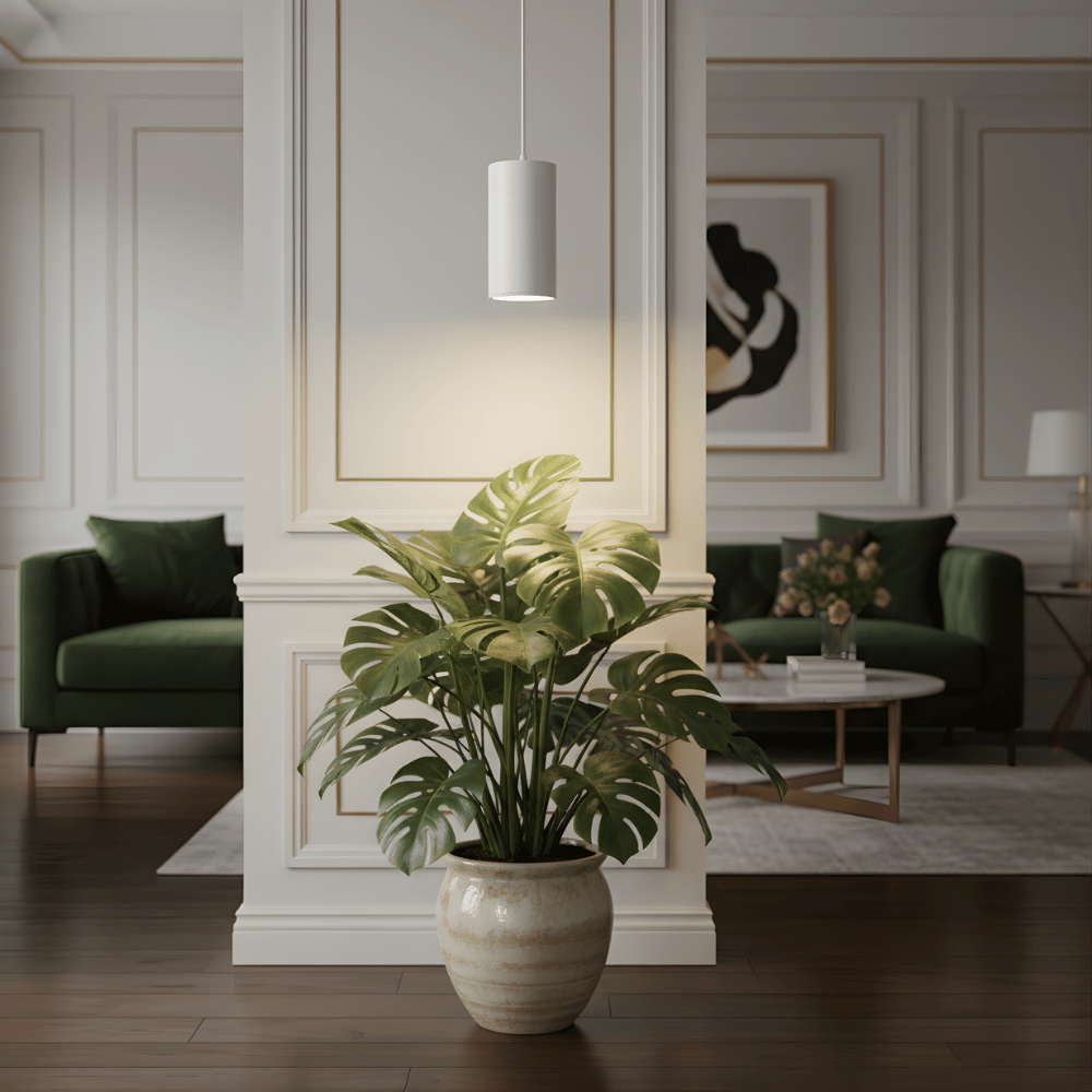Living room with a potted plant and pendant grow light in the foreground and a green sofa in the background.