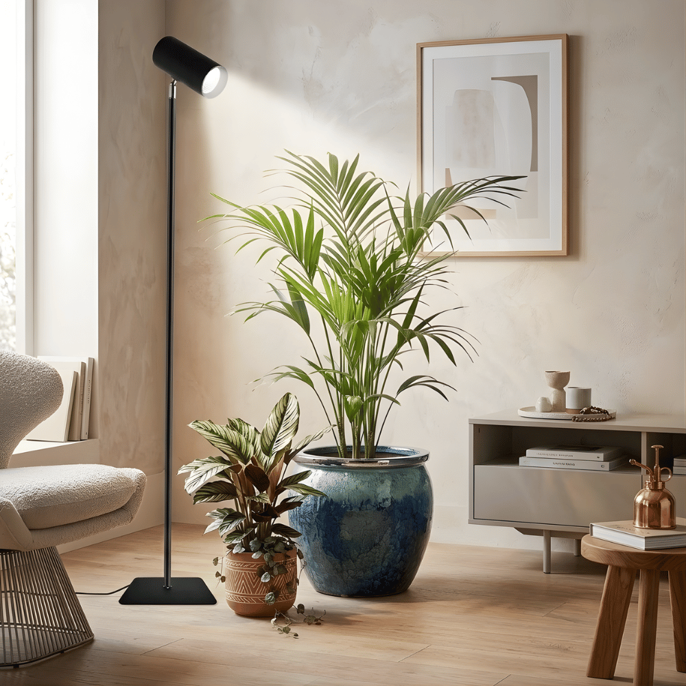 Modern living room with potted plants, a floor grow light, and a framed picture on the wall.