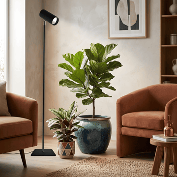 Living room with brown armchairs, a floor grow light, and potted plants.