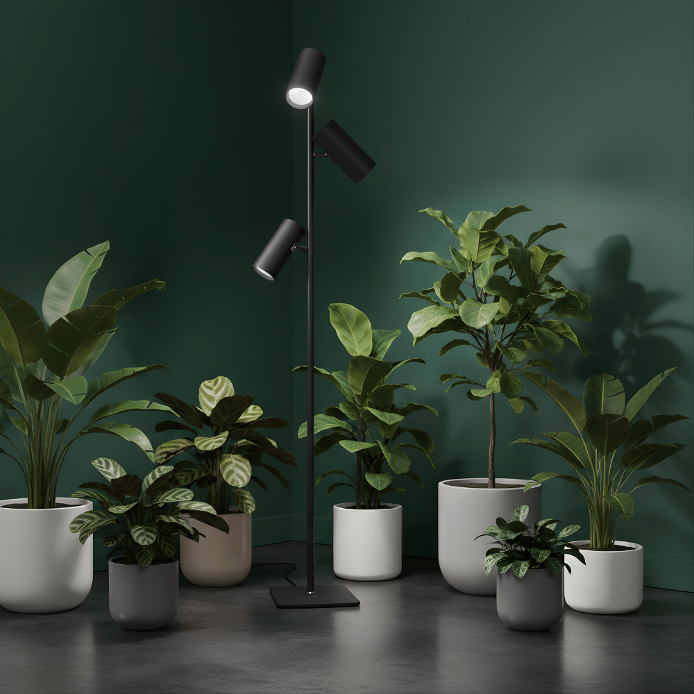 Modern black floor plant grow light with three potted plants in a room setting.