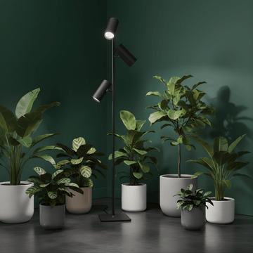 Modern floor grow light with two spotlights on a dark green wall background with potted plants.