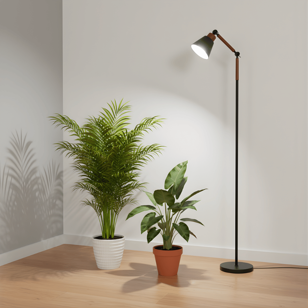 Floor grow light with two potted plants on a wooden floor against a white wall.